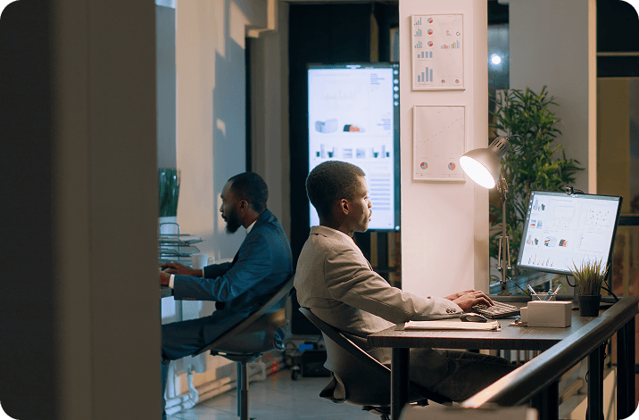 Two colleagues working with analytics dashboards in an office